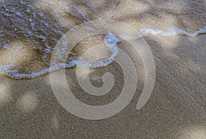 Soft waves of blue ocean, white foam on tropical beach