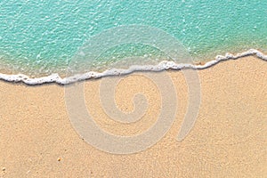 Soft waves with foam of blue ocean on the sandy beach