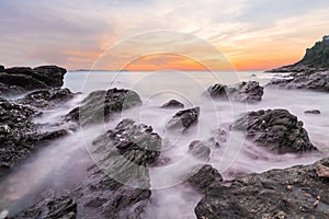 Soft waves of ocean in sunset with stones on the beach foreground at Khao Laem Ya Mu Ko Samet National Park Rayong