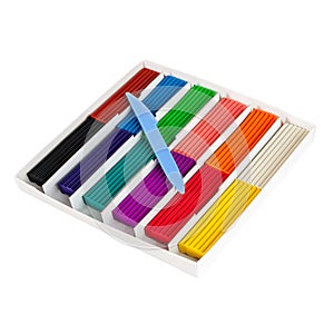 Soft wax plasticine of different colors in a box with a knife for dividing into pieces, isolated on a white background