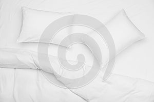 Soft white pillows and blanket on bed