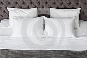 Soft white pillows on comfortable bed