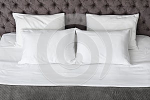 Soft white pillows on comfortable bed photo