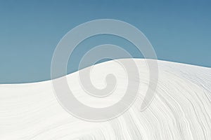 Soft white sands under a clear blue sky create a serene landscape in the desert