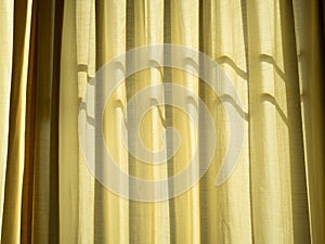 Soft yellow linen texture blinds curtains with sunlight through the windows. sun-blind