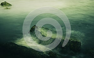 Soft Zen-like Seascape of Rolling Waves over the Rocks on the Beach