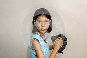 Softball girl,Asian girl holding a softball and gloved hand in the other hand