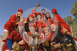 Softball Team And Coach With Trophy Celebrating Against Sky