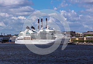 Soften edge envelope size view of large white colored ocean ship in Neva river of Saint Petersburg under blue summer cloudy sky