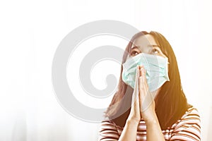 Softfocus of Young woman in hygienic mask are praying