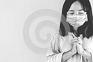 Softfocus of Young woman in hygienic mask are praying