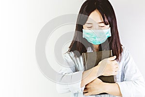 Softfocus of Young woman in hygienic mask are praying