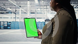 Software developer in data center using green screen tablet