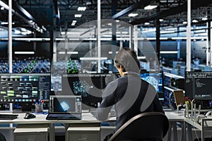 Software developer in data center using PC, managing AI training datasets