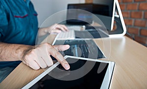 Software developer is pointing to the paper working and analyzing together the code written into the program on the computer