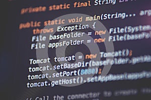 Software developer programming code. Abstract computer script code closeup on monitor screen with bokeh