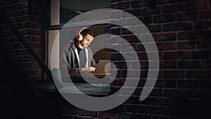 Software Developer Programming on a Laptop Late at Night. Male Specialist Browsing Internet