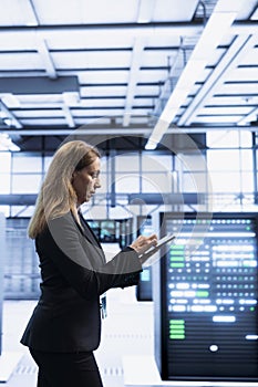 Software developer using tablet in data center with advanced tech