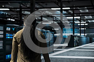 Software developer walking through server room rows