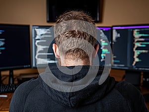 Software developer working on multiple monitors.