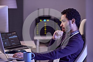 Software developer working at night writing code at desk