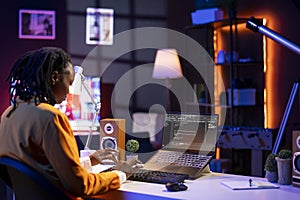 Software developer writes code on laptop screen in apartment office