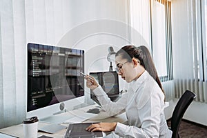 Software developers are analyzing about the code written into the program on the computer in office room
