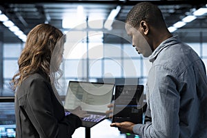 Software developers in data center coding on laptop