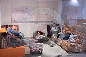 Software developers sleeping on sofa in creative startup office