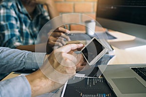 Software developers are using smart phones and analyzing together the code written in the program on the computer