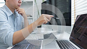 Software development concept, Male programmer pointing on laptop screen to checking data codes