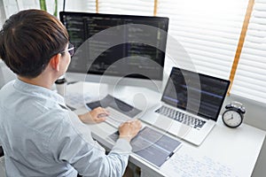 Software development concept, Male programmer typing data code and working on multiple screens