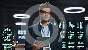 Software engineer posing server room datacenter portrait. Man looking camera