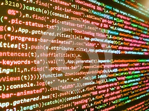 Software engineer at work. Digital binary data on computer screen. Programming source code abstract screen of software developer.