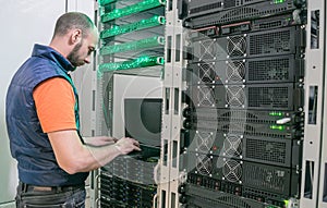 Software engineer is working in a modern data center.Young man diagnoses problems in the work of the information center. System