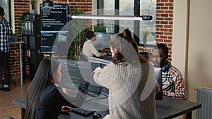 Software programer pointing pencil at source code on computer screen explaining algorithm to coworker
