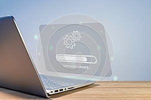 Software system update process concept. A laptop on the table with updating progress bar on virtual screen