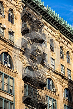 Soho brick building with fire escape, ornate cornice, New York