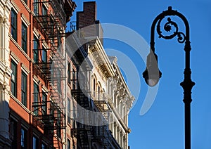 Soho building facades with cornices, fire escapes and a lamp-post. Manhattan, New York City