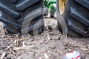 Soil compaction caused by a dual tractor tires over topsoil dirt in an empty field before planting.