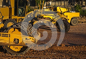 Soil compactor with vibratory padfoot drum. Heavy duty machinery working on highway construction site. Vehicle for soil