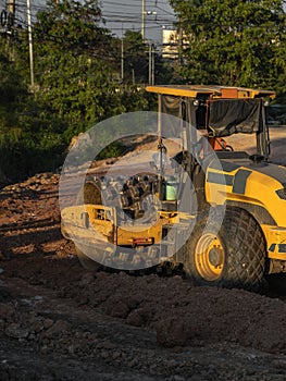 Soil compactor with vibratory padfoot drum. Heavy duty machinery working on highway construction site. Vehicle for soil