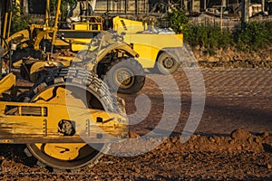 Soil compactor with vibratory padfoot drum. Heavy duty machinery working on highway construction site. Vehicle for soil