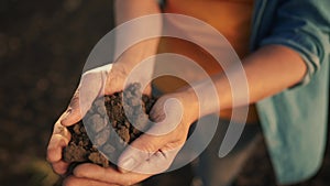 soil in the hands of the farmer. agriculture. close-up a of farmers hands holding black soil in their hands, fertile