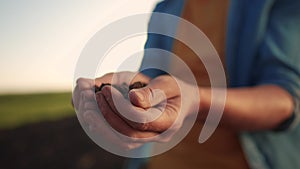 Soil in the hands of the farmer. Agriculture. Close-up a of farmers hands holding black soil in their hands, fertile