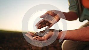 soil in the hands of the farmer. agriculture. close-up of a farmers hands holding sun black soil in their hands, fertile