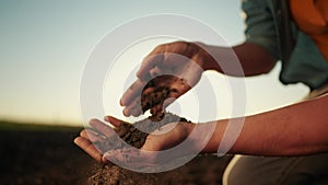soil in the hands of the farmer. agriculture. close-up of a farmers sun hands holding black soil in their hands, fertile