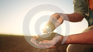 soil in the hands of the farmer. agriculture. close-up sun of a farmers hands holding black soil in their hands, fertile