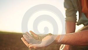 soil in the hands of the farmer. sun agriculture. close-up of a farmers hands holding black soil in their hands, fertile