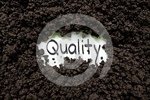 Soil quality for agriculture concept. Written word on piece of paper on soil.